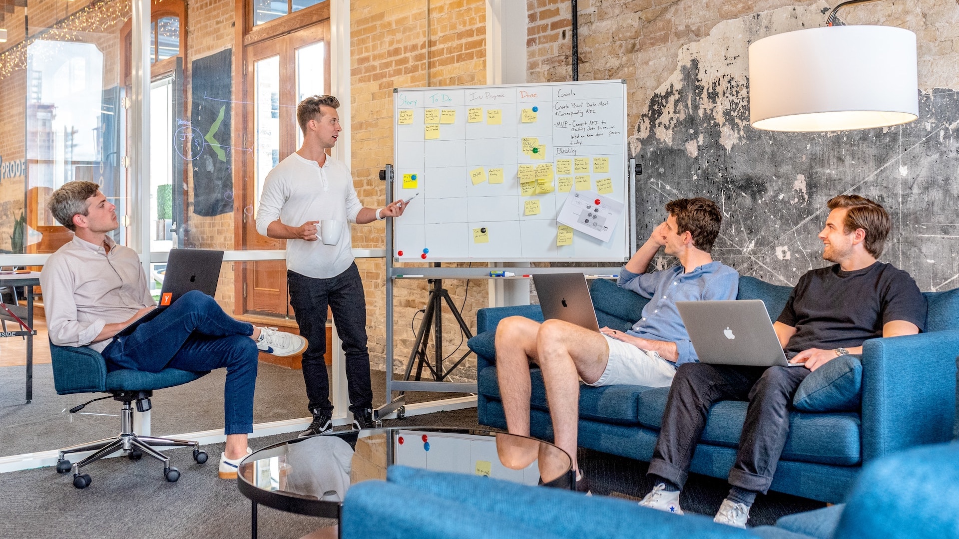 A group of people gathered in front of a whiteboard discussing task execution and planning