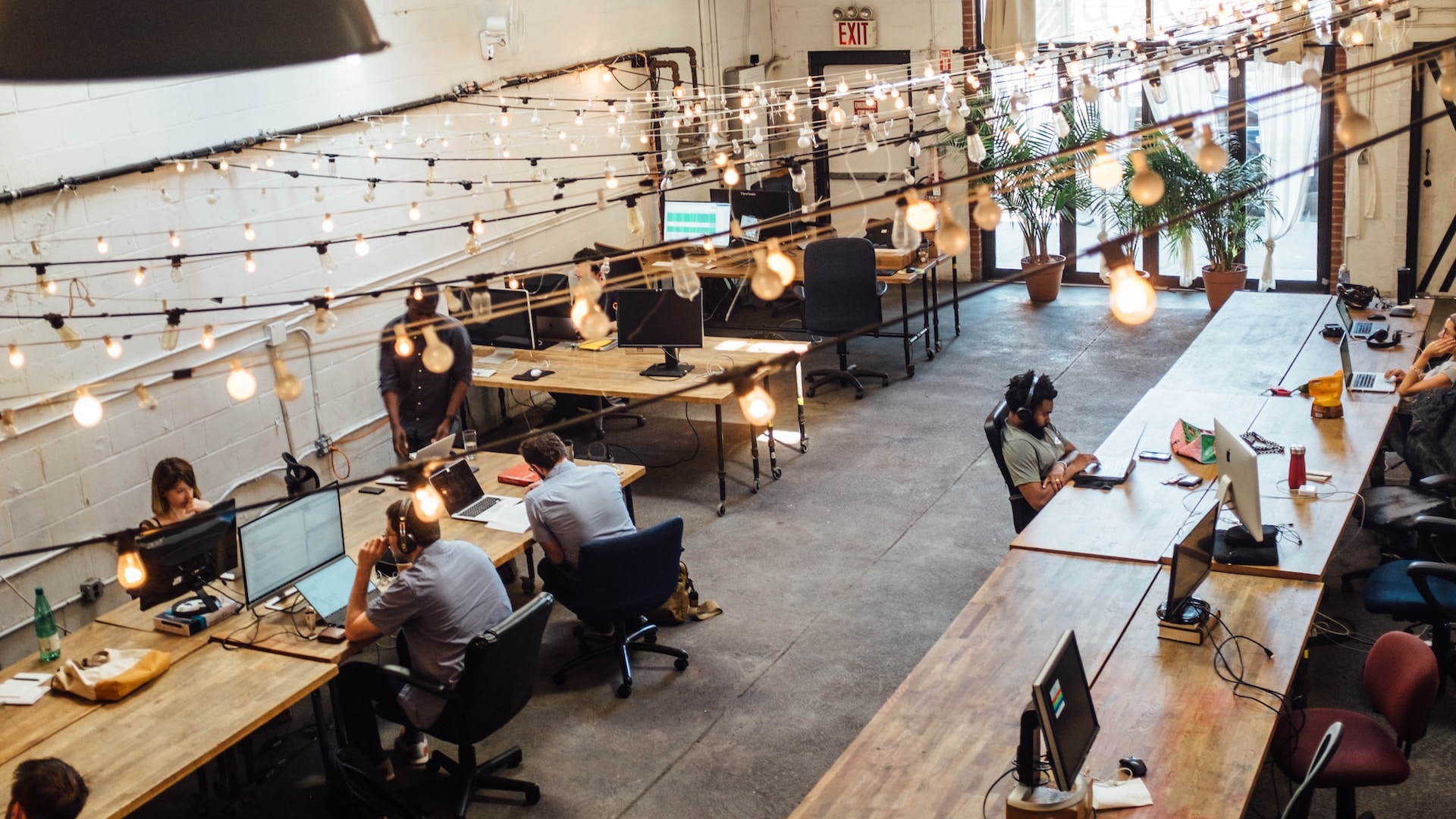 An open plan office with multiple people working and a few empty workspaces among them